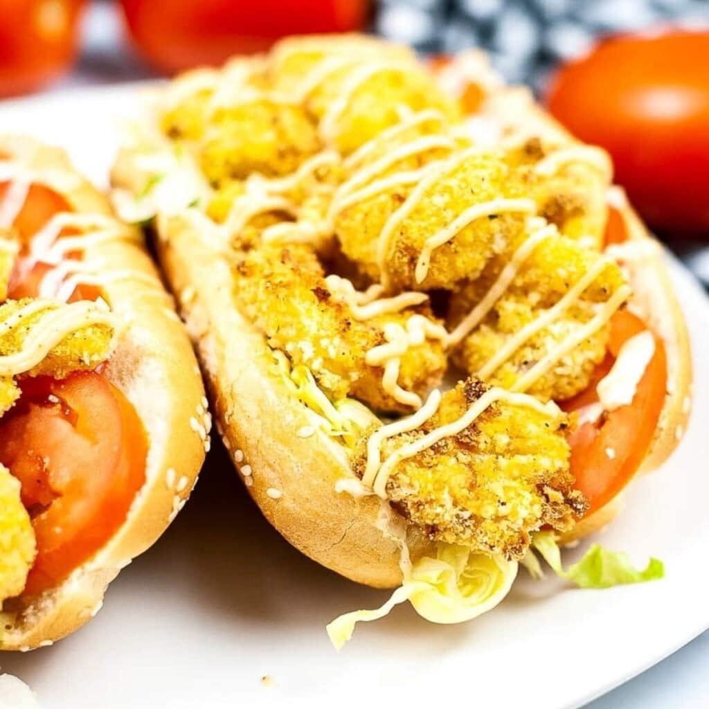 Closeup view of shrimp o'boy sandwiches on a white plate.