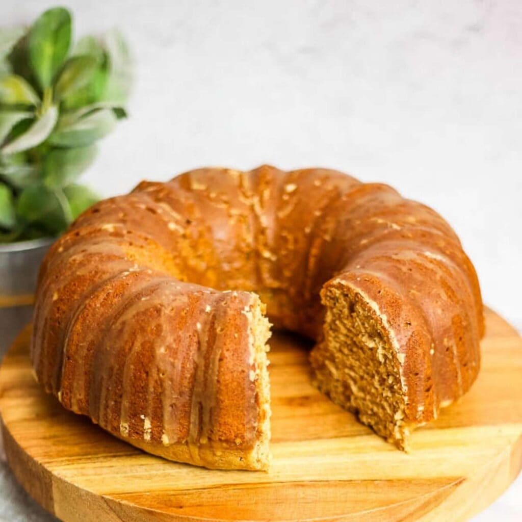 chai bundt cake on a wooden board with a slice removed.