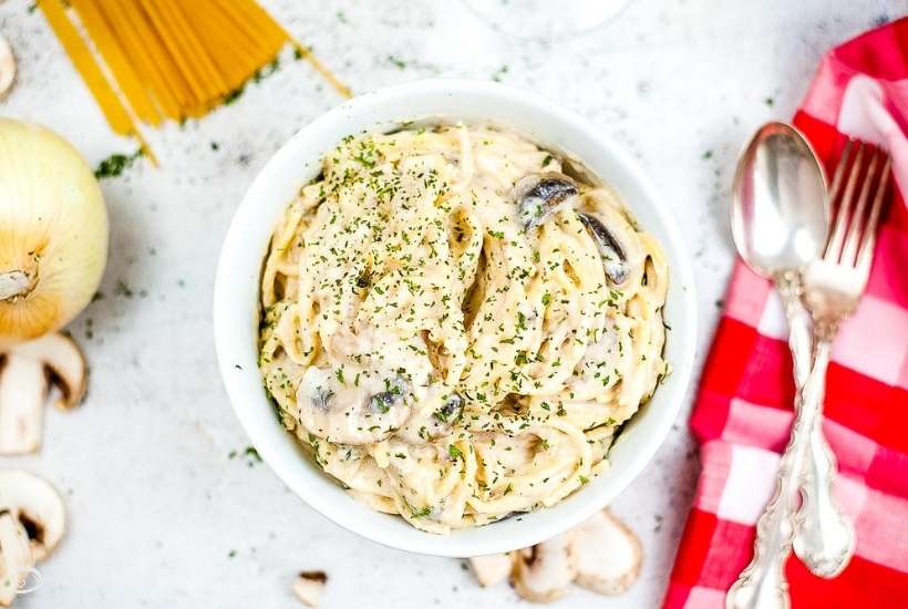 bowl of Instant Pot chicken Tetrazzini next to fork and spoon.