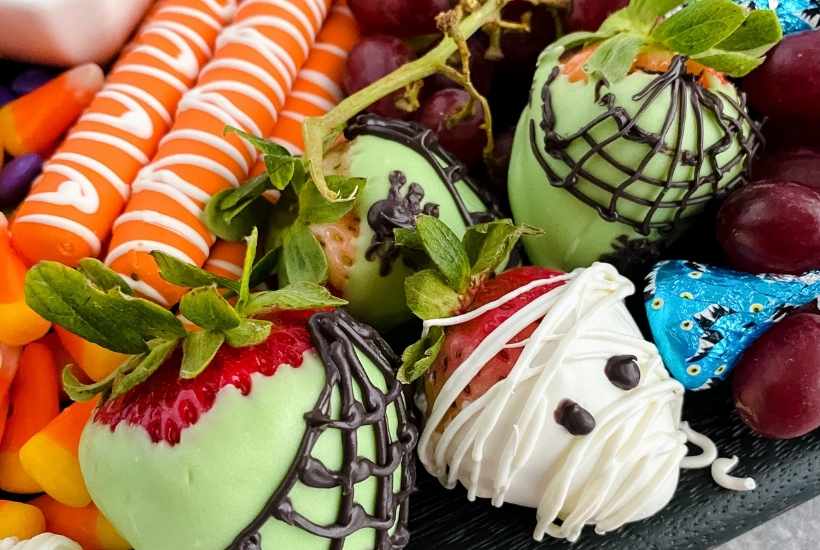 close up of halloween dessert board with fruits and candy