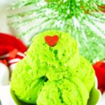 4 scoops of grinch edible cookie dough in a bowl topped with heart sprinkle