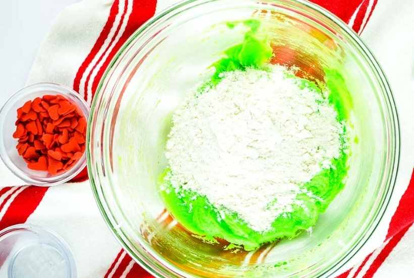adding flour to the neon green dough