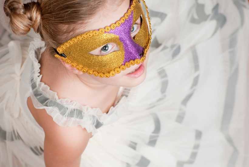 Young girl wearing a mask for a New Year's Eve masquerade party.