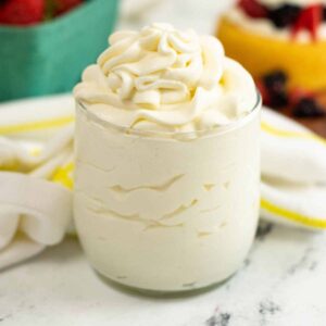 Close up view of stabilized whipped cream frosting in a glass cup.