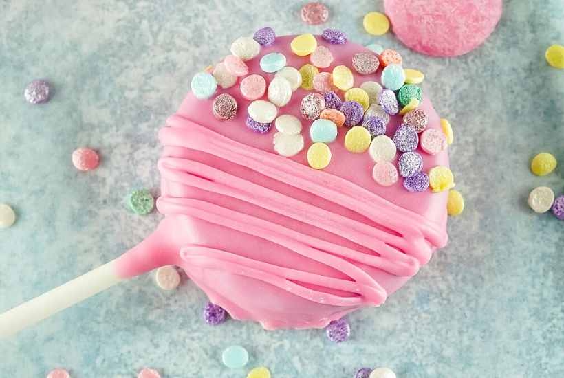 Top view of a valentines day cookie pop decorated with pastel colored sprinkles.