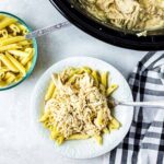 crockpot olive garden chicken shredded on top of a white plate with noodles