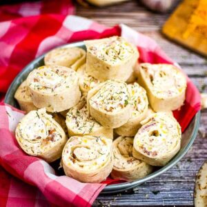 crack chicken pinwheels stacked on a plate with plaid dish cloth