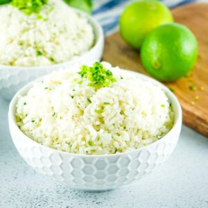 cilantro lime rice in two bowls next to whole limes on a cutting board