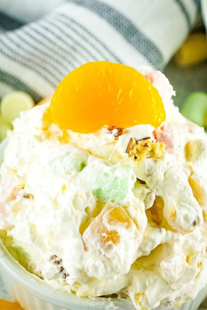 ambrosia salad in small bowl topped with a mandarin orange slice