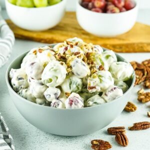 close up of grape salad topped with nuts in a small bowl