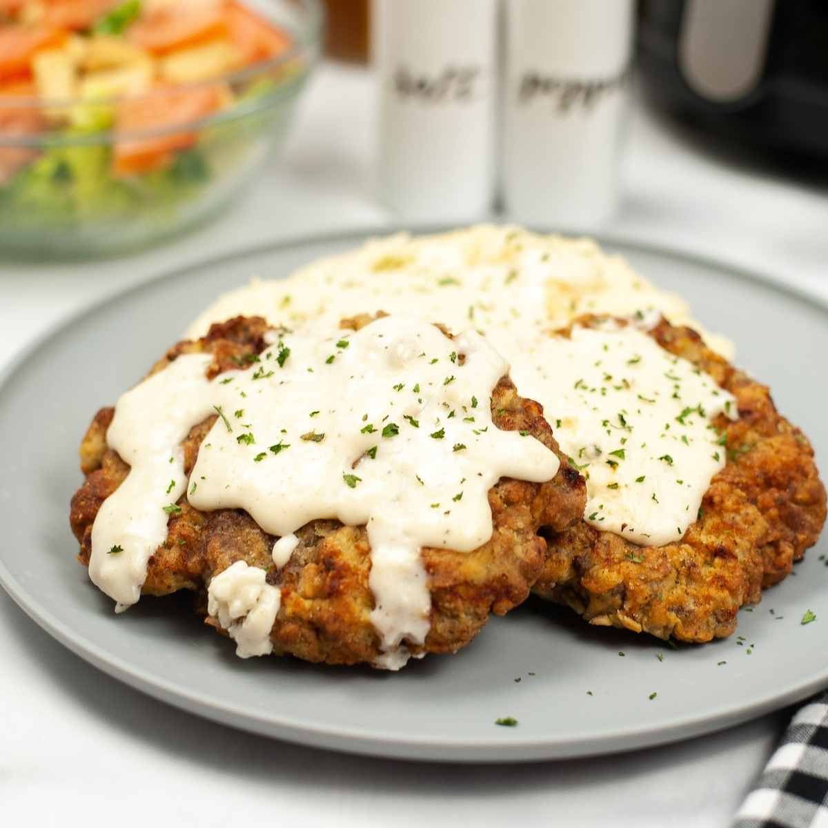 close up of air fryer chicken fried steak on a gray plate