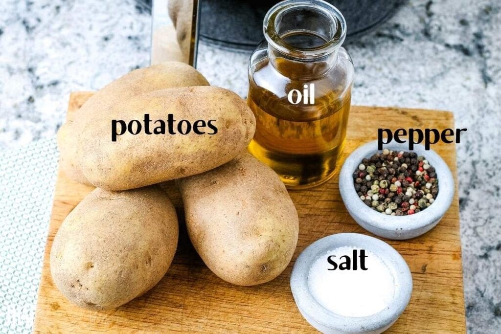 labeled ingredients for baked potatoes in the air fryer on a wood cutting board