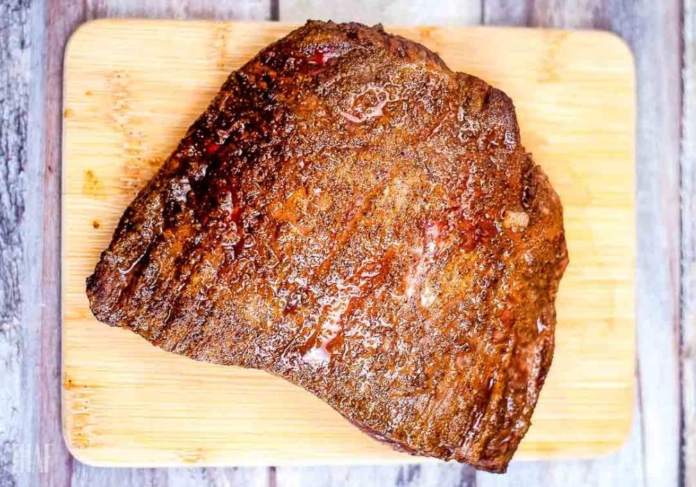 uncut flank steak on a wooden cutting board