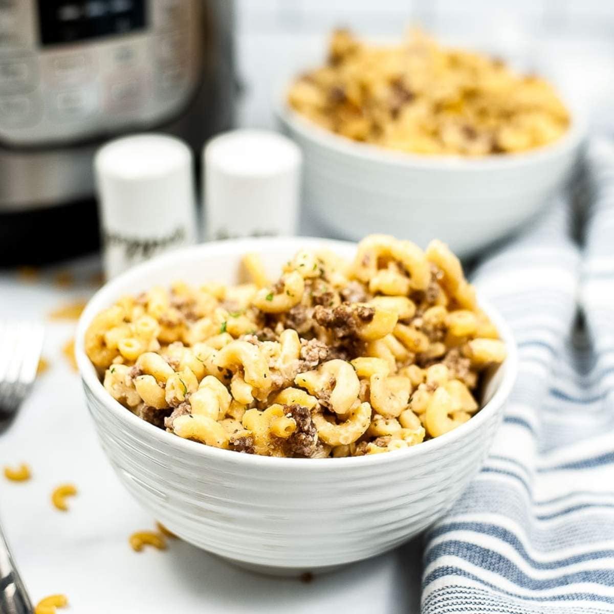 two bowls of instant pot hamburger helper made with macaroni noodles.
