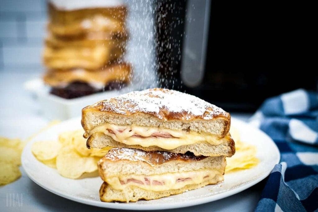air fryer monte cristo sandwich being dusted with powdered sugar