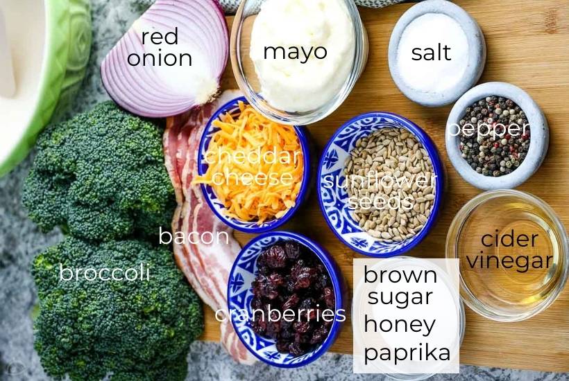 Labeled ingredients for broccoli salad with cranberries and bacon.