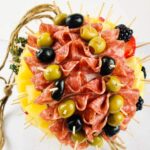 Charcuterie ball drop with jute cord tied to hang it up like a piñata.