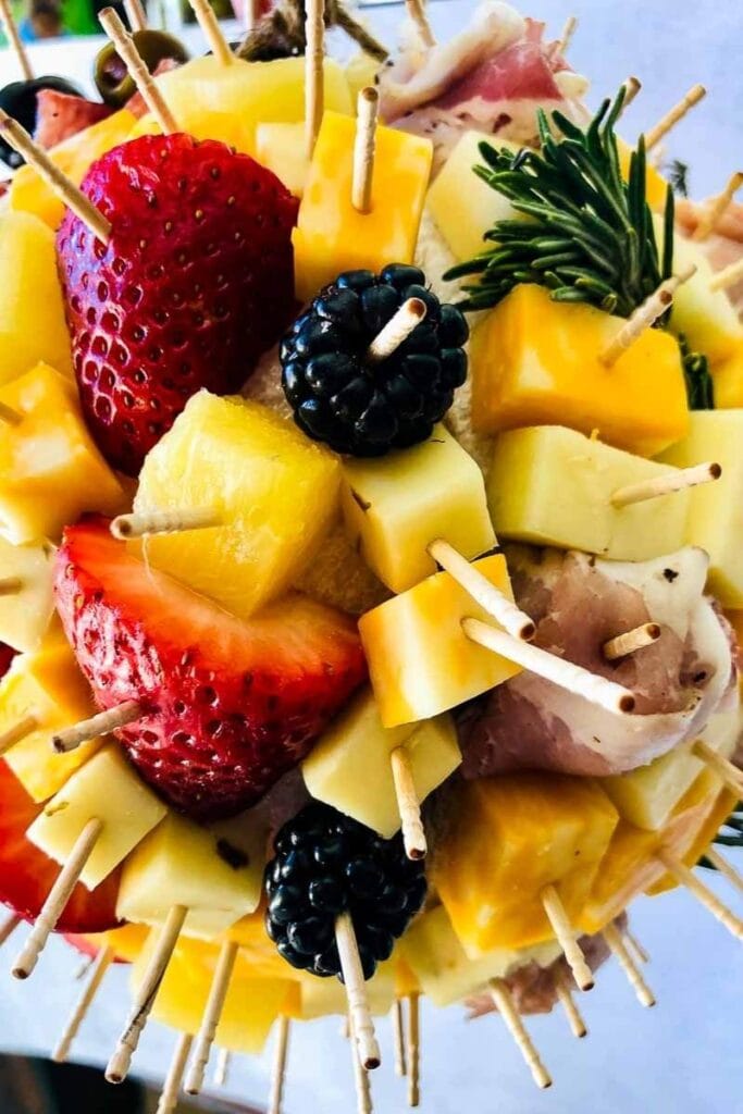 fruit and cheese on toothpicks stuck in the charcuterie ball