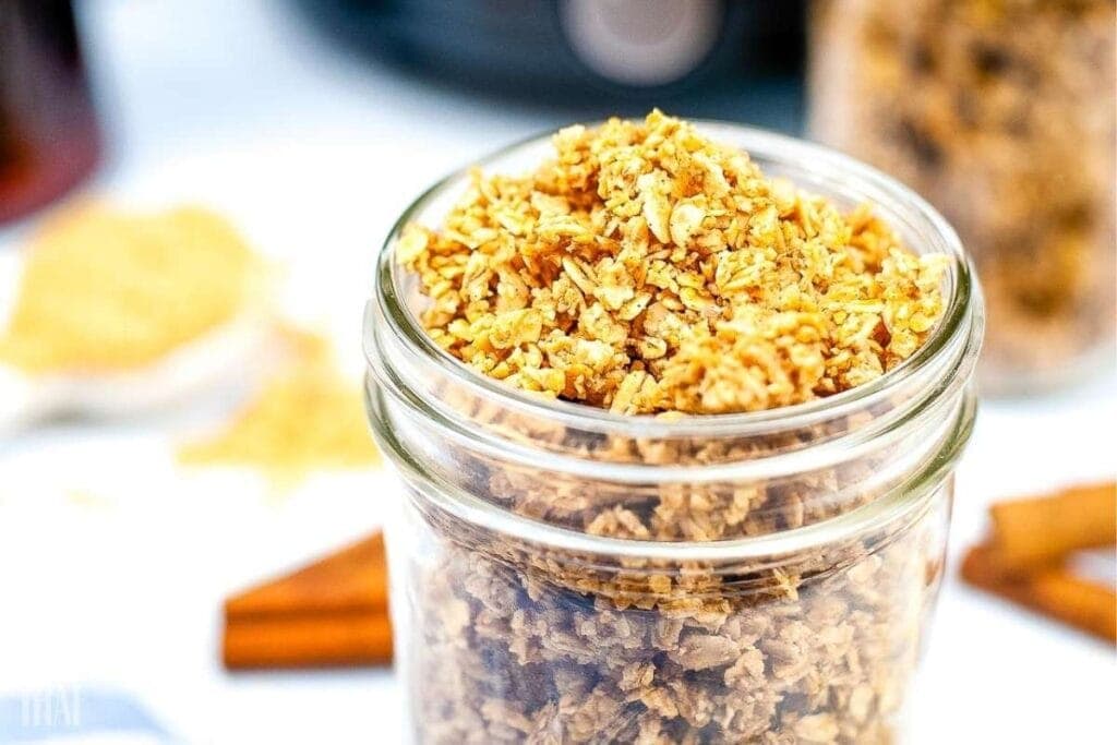 Closeup view of clear jar filled with air fried granola.