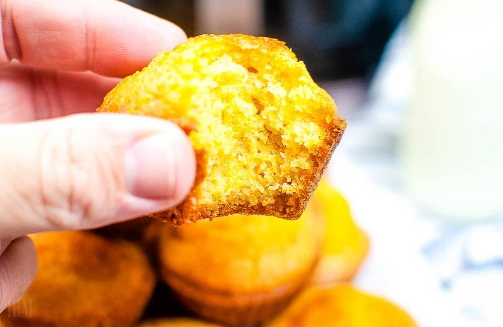 holding an air fried cornbread muffin with a bite taken out