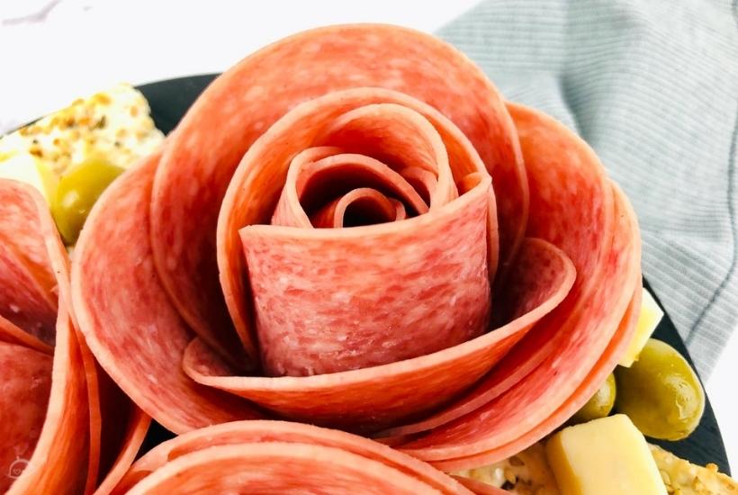 close up of a salami rose on a charcuterie board