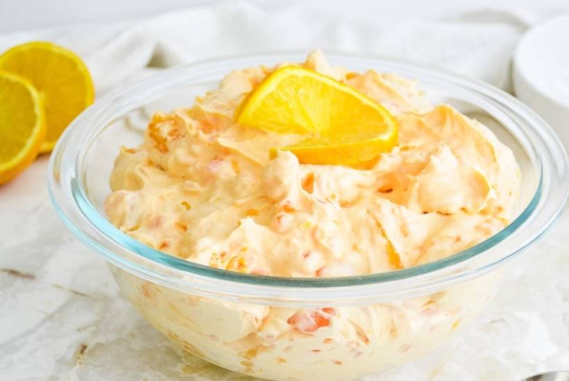 Clear glass bowl filled with orange fluff salad.