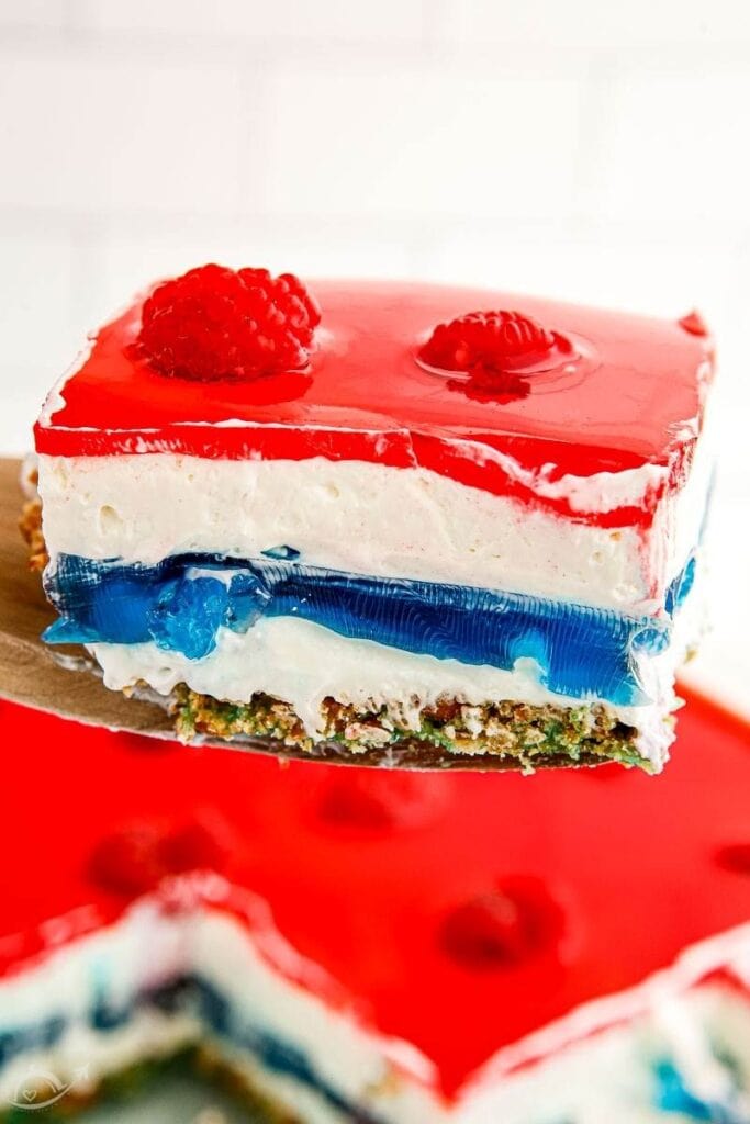 a square of red white and blue pretzel salad on a server