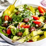 close up of copycat Panera Greek Salad in a large white bowl with a fork