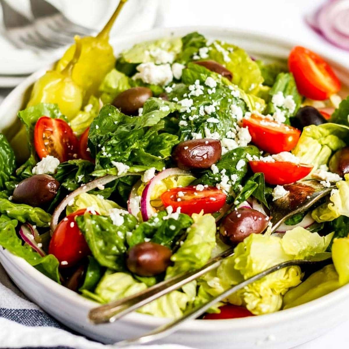 close up of copycat Panera Greek Salad in a large white bowl with a fork