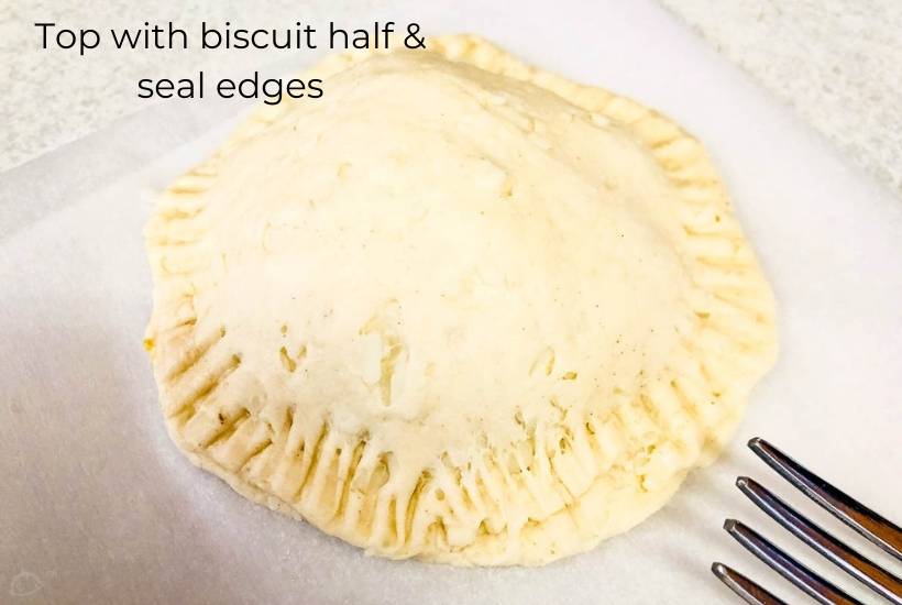 a stuffed breakfast bomb with edges that have been crimped with a fork