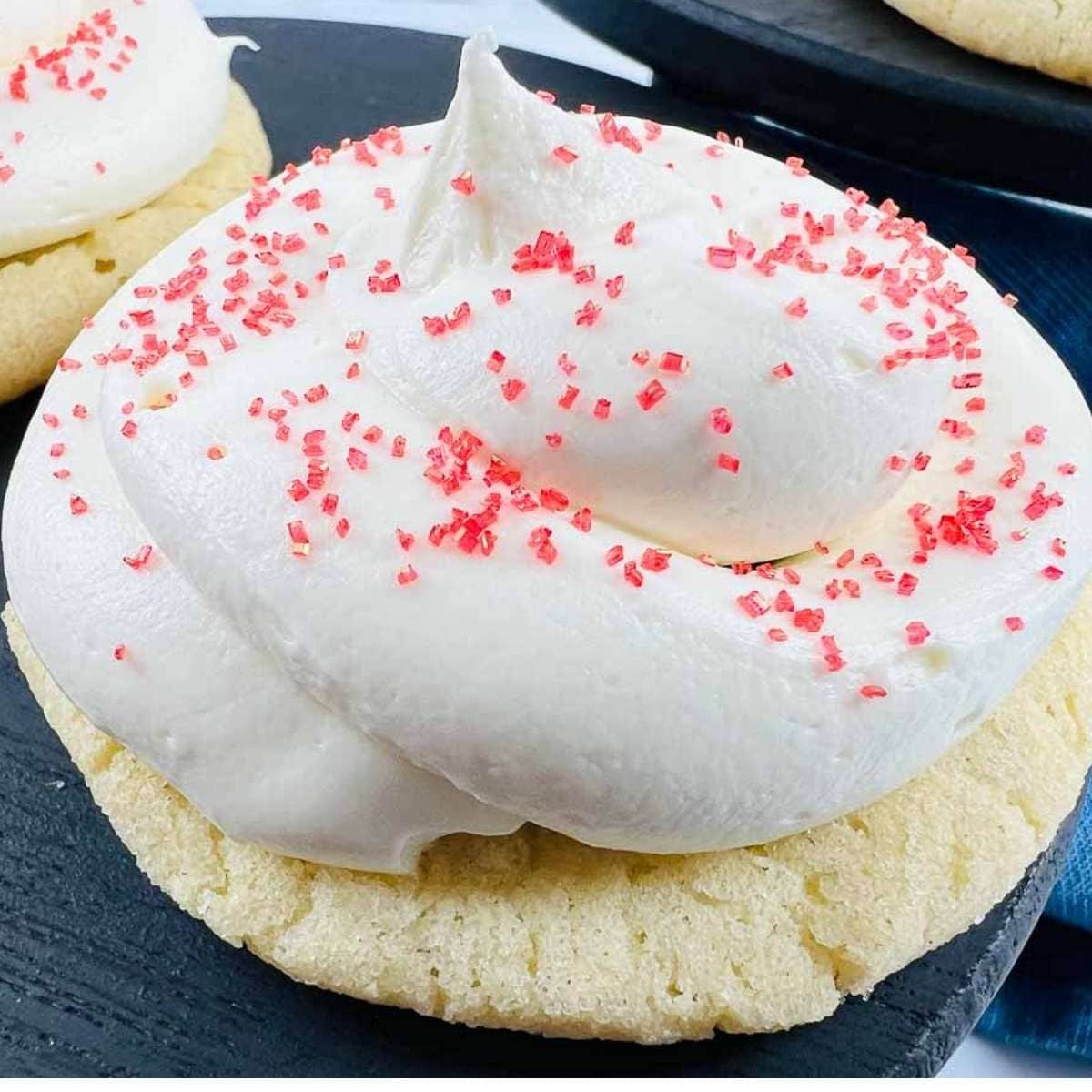 closeup view of strawberry marshmallow cookie with red sprinkles on top.