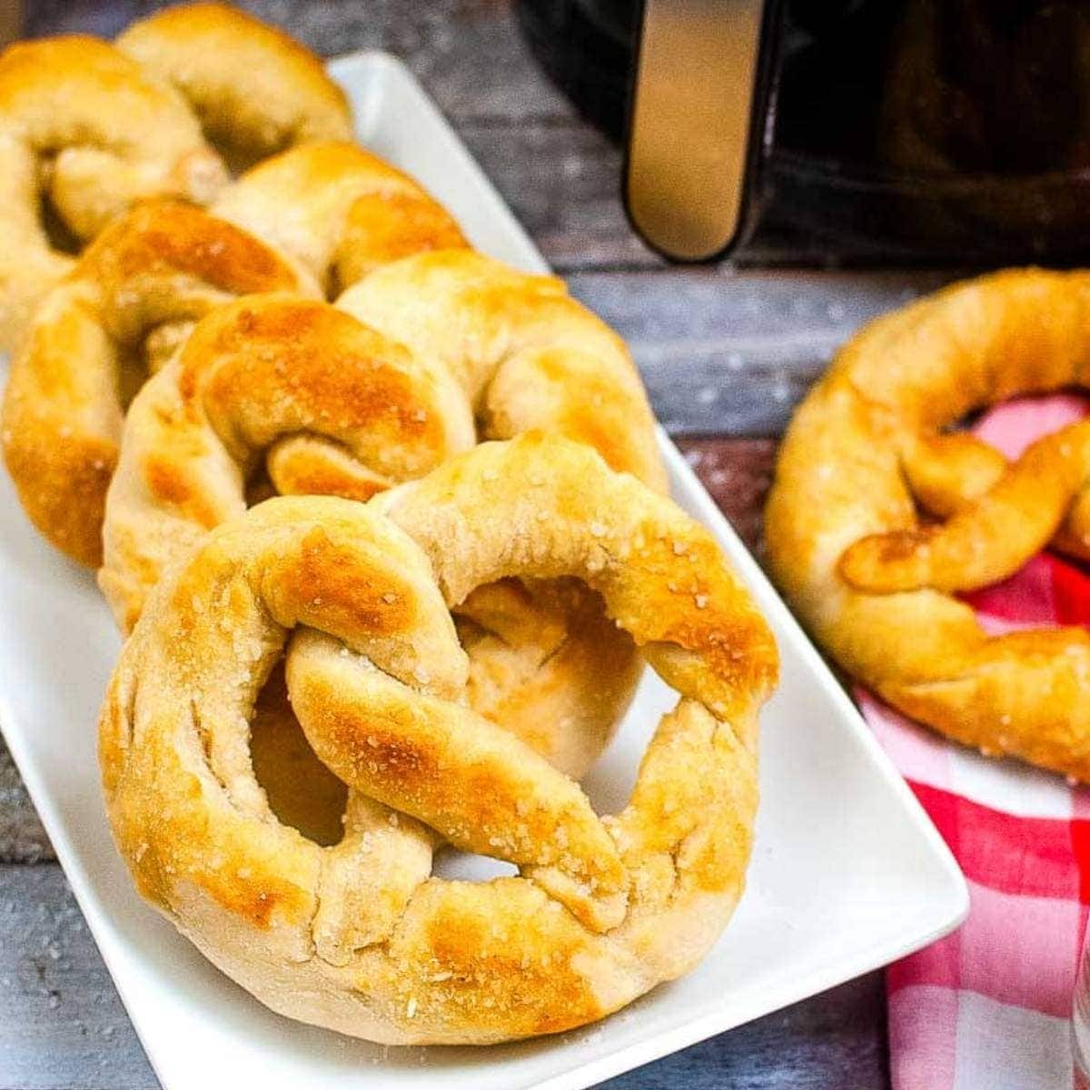 four air fried soft pretzels on a white plate