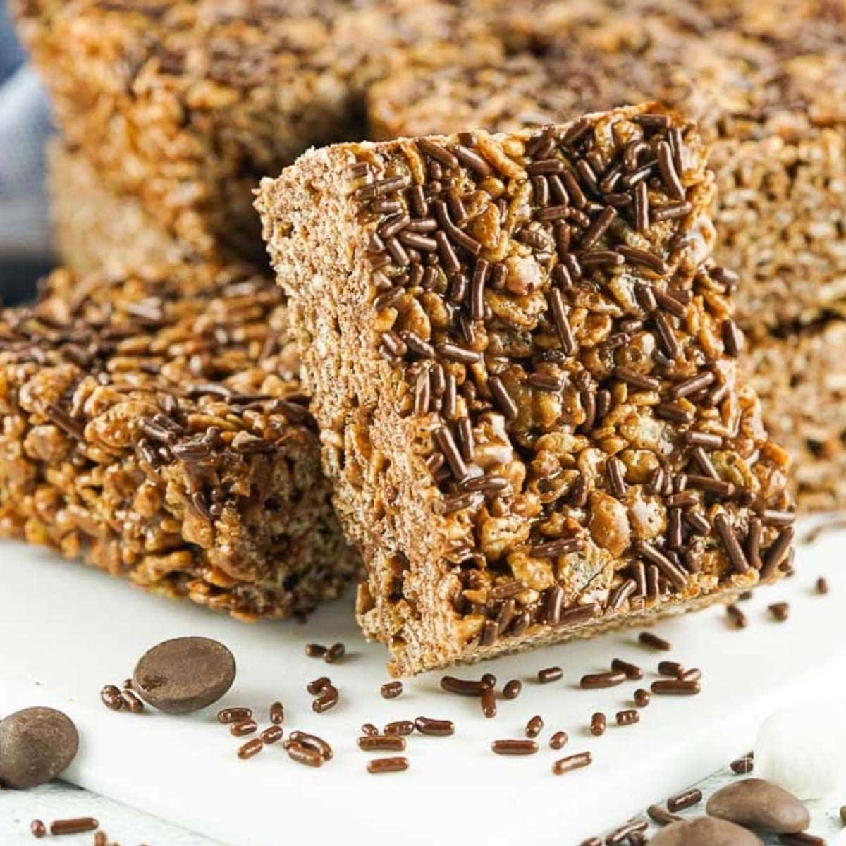 squares of chocolate Rice Krispie treats with brown sprinkles on top.