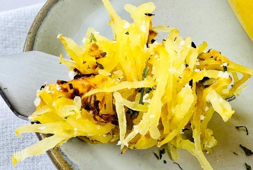 close up of a forkful of air fried spaghetti squash with parmesan cheese.