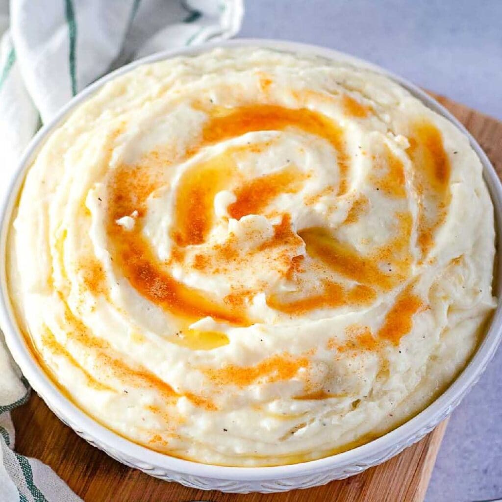 top view of Amish mashed potatoes in a white bowl drizzled with browned butter