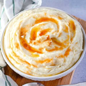 top view of finished amish mashed potatoes with drizzled brown butter in a white bowl