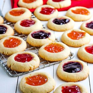 strawberry jam cookies on a wire cooling rack with some on the counter