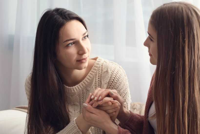 Two female friends holding hands.