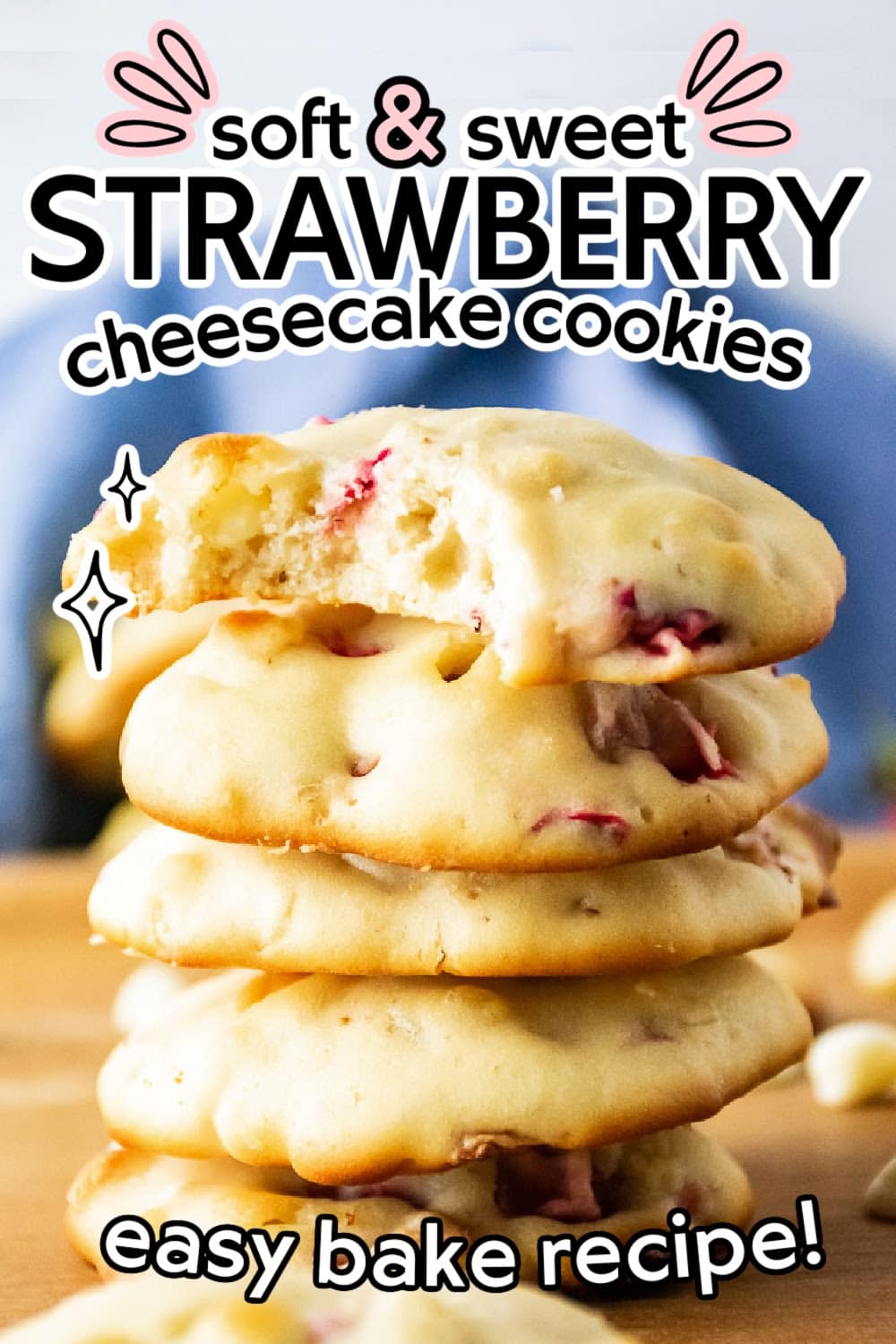 Stack of strawberry cheesecake cookies with a bite taken from the top one with text overlay.