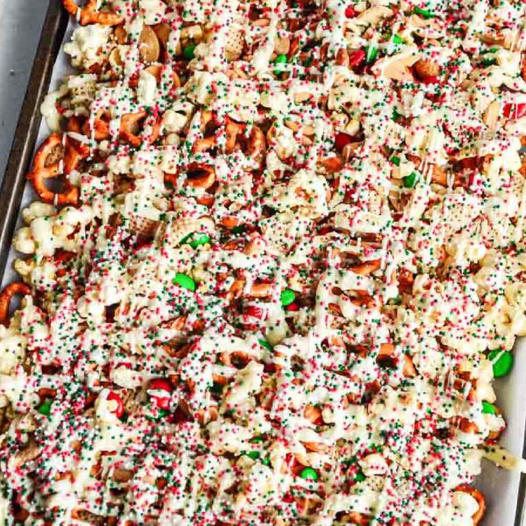 baking sheet lined with parchment paper filled with christmas crack chex mix
