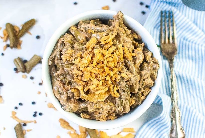 top view of green bean casserole in a small dish next to a fork.