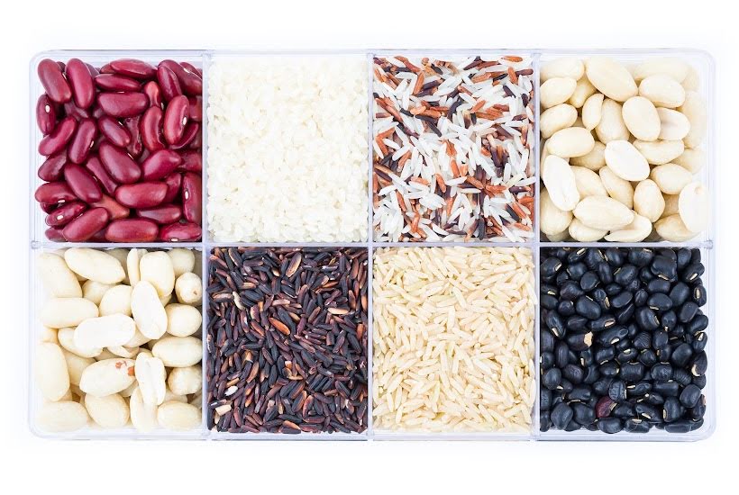 Eight different kinds of beans and rice in a container with dividers.