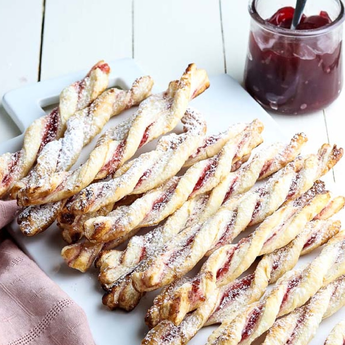 top view of raspberry pastry twists next to a jar of raspberry jam.