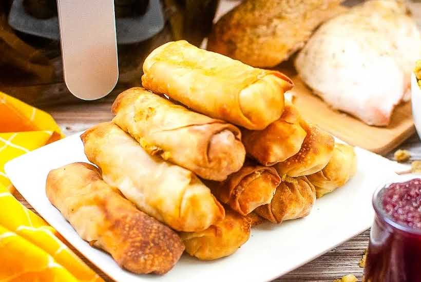 stacked Thanksgiving egg rolls on a white plate.