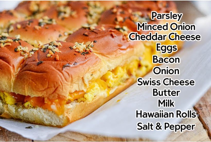 front view of Hawaiian rolls breakfast sandwiches on parchment paper with a text overlay of ingredients.