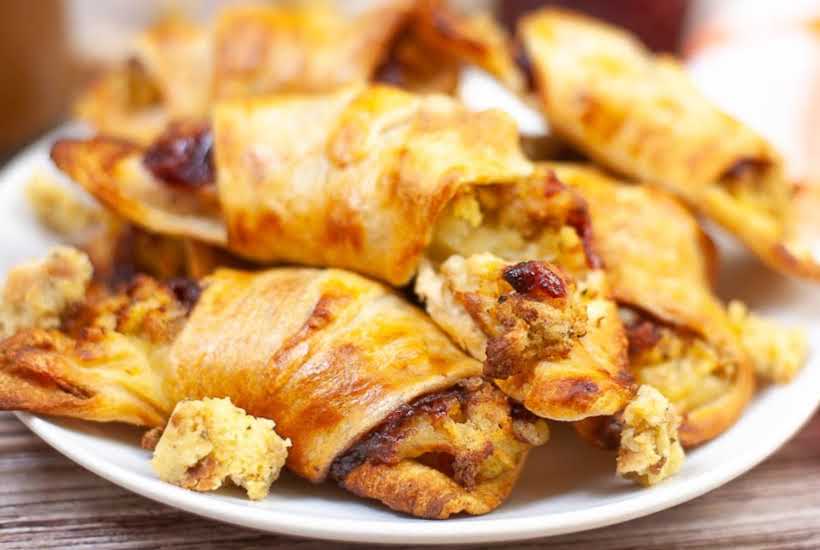 leftover turkey crescent rolls stacked on a white plate.