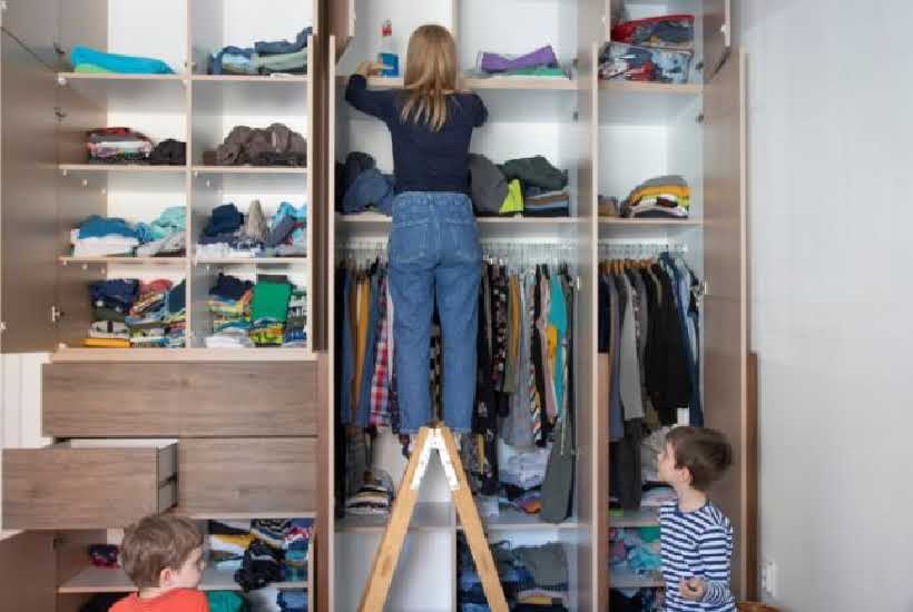 woman and two children organizing a closet.
