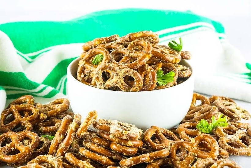 white bowl filled with baked ranch pretzel recipe surrounded by more seasoned pretzels.