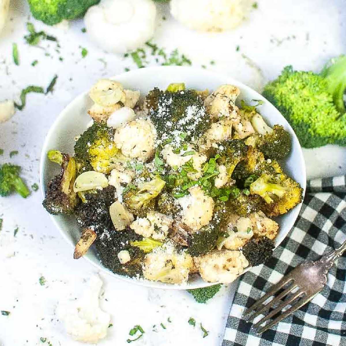 top view of air fryer broccoli and cauliflower in a white bowl.