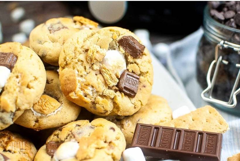 a stack of smores cookies next to chocolate bar and chocolate chips.